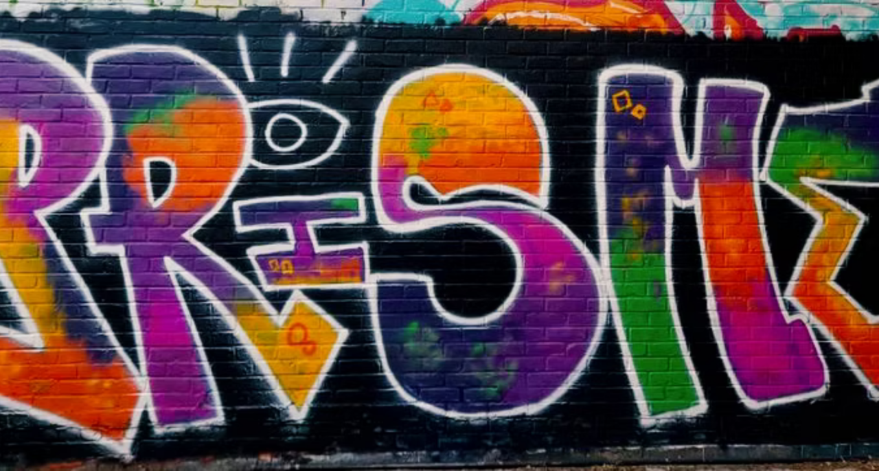 "Le Prisme" écrit en graffiti sur un mur