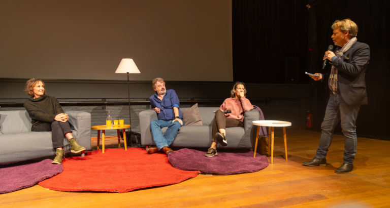 artistes dans un fauteuil devant le gradin pour une conférence