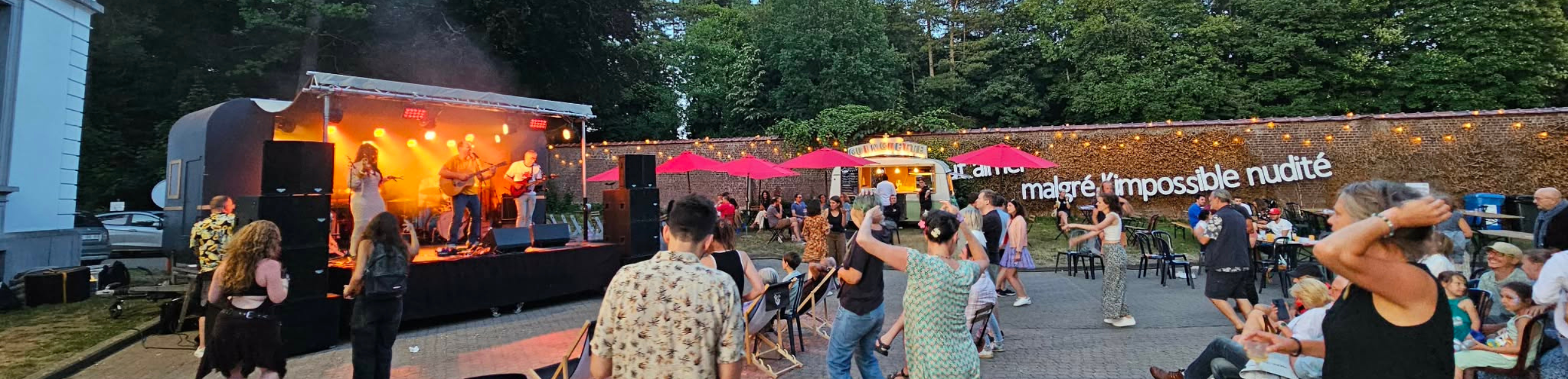 personnes qui dansent devant la scène à la guinguette