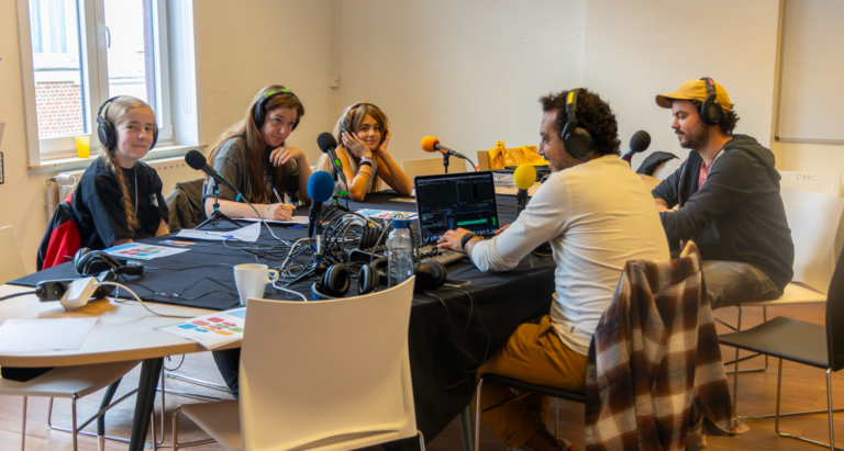 groupe autour d'une table pour un atelier radio avec micros